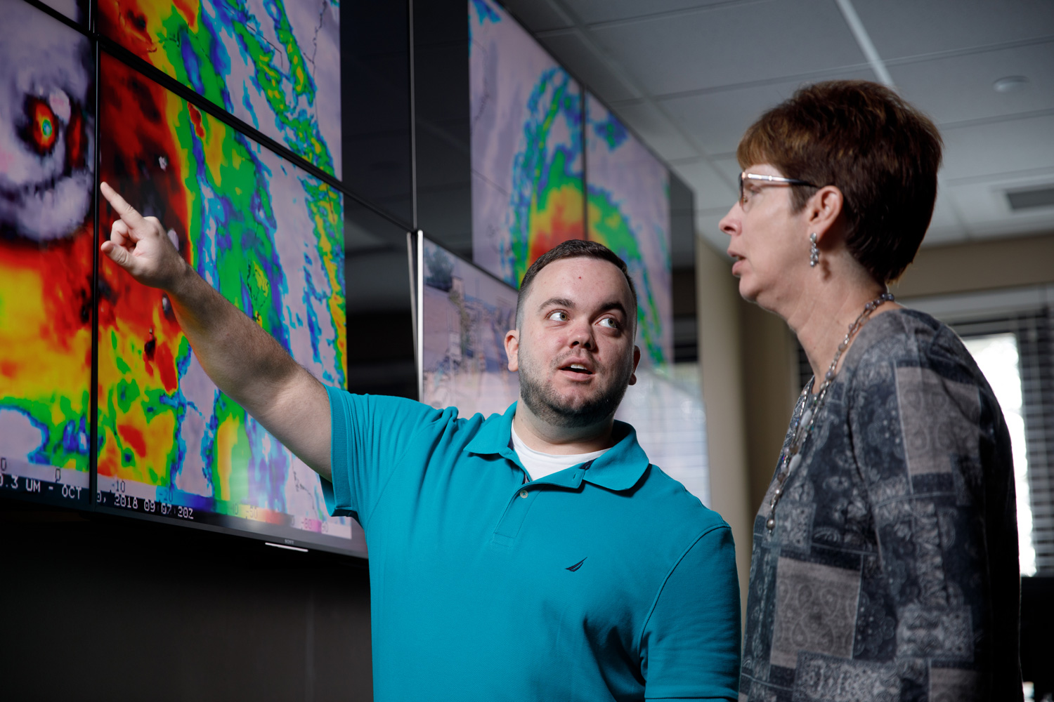 two UA researchers studying a weather radar