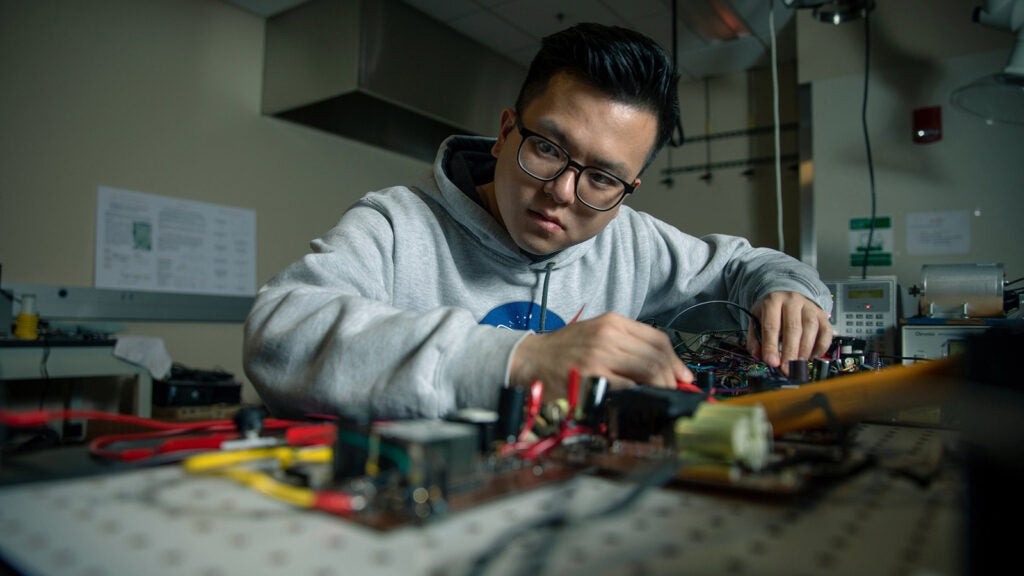a researcher intently looking at wires